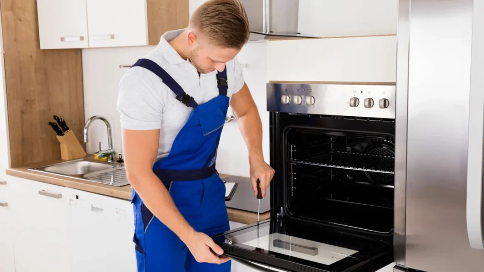 Same-day appliance repair in Tampa technician fixing an oven door in a residential kitchen.