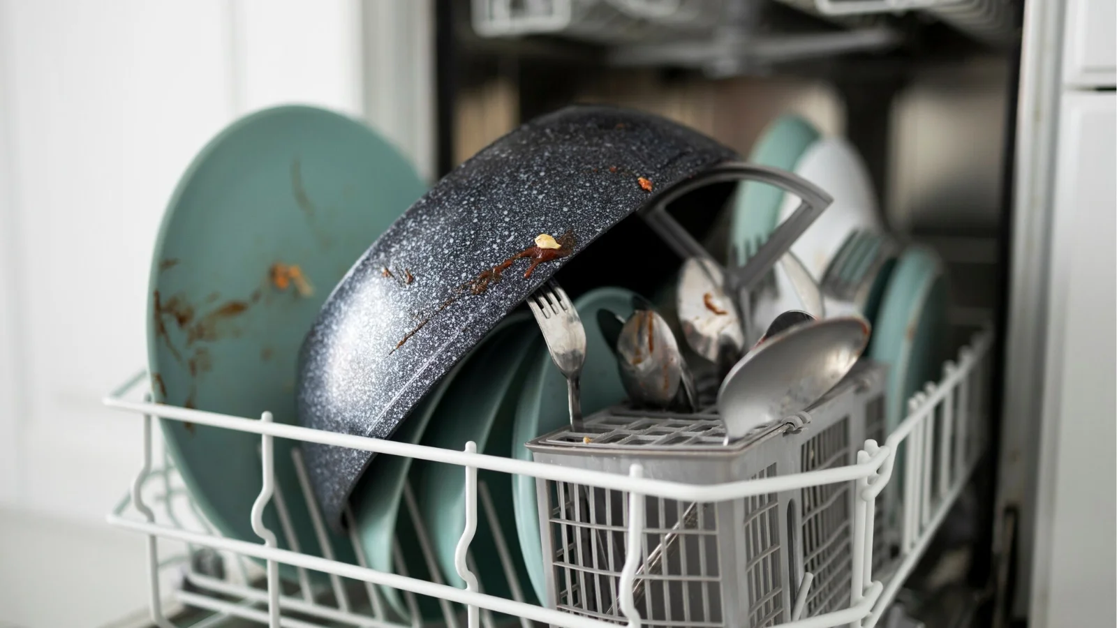 Dirty dishes inside a dishwasher showing common cleaning issues requiring Orlando dishwasher repair