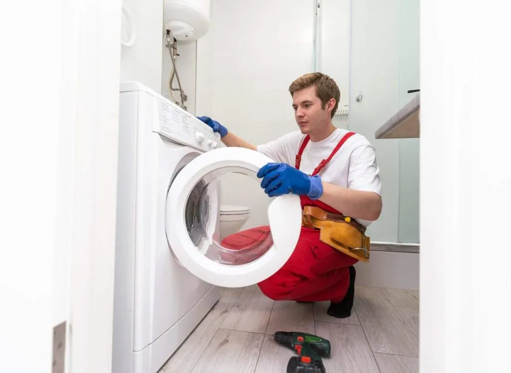 Plumber Fixing Domestic Washing Machine.
